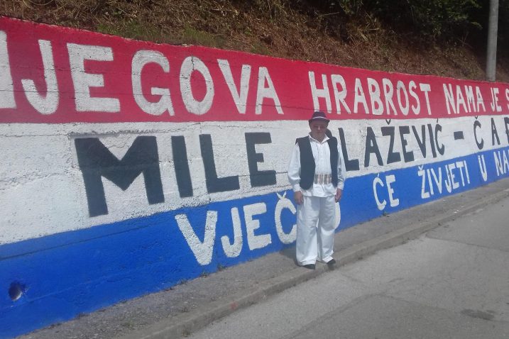 Svjedok masakra Mile Begić ispred velikog grafita na potpornom zidu s kojeg je Čađo skočio među najveće heroje Domovinskog rata / Foto A. RAVLIĆ