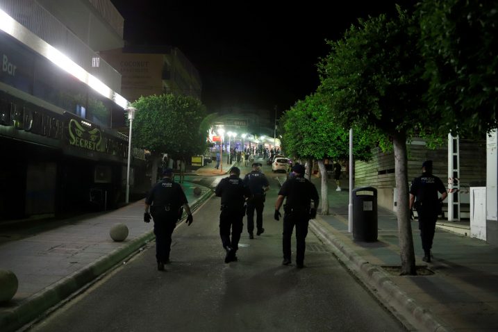 Policijski dužnosnici nose maske dok patroliraju ulicom Punta Ballena u Magalufu / Reuters