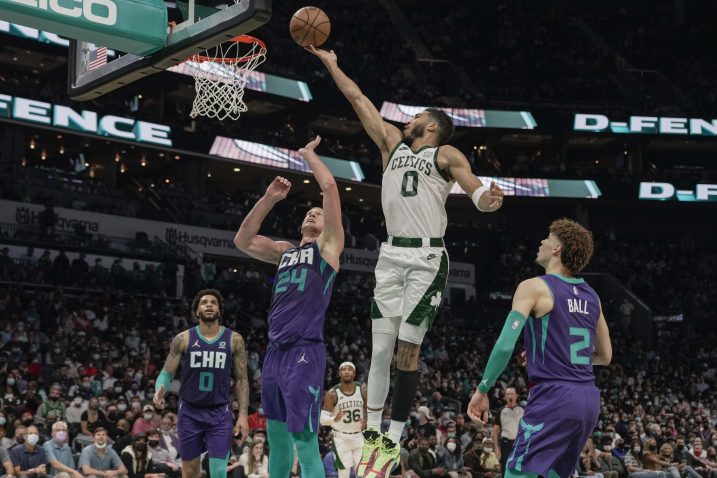 Jayson Tatum polaže loptu u koš preko Masona Plumleea/Foto REUTERS