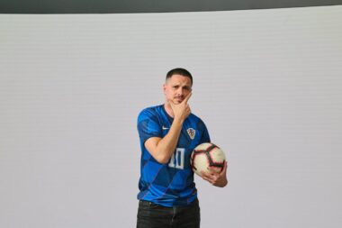 Ivan Forjan / Foto Nova TV O raspletu Lige nacija čije je utakmice komentirao u programu Nove TV, o velikim pobjedama Hrvatske u uvodnim utakmicama kvalifikacija te o svome dugogodišnjem radu na televiziji koja slavi četvrt stoljeća, na stranicama televizijskog priloga razgovaramo s Ivanom Forjanom. Ivane, nedavno ste u programu Nove TV komentirali utakmice „Final foura“ Lige nacija. Za početak, dojam da se ta Liga nacija ustalila kao dobro rješenje i kao da je sve manje skeptika koji osporavaju to natjecanje? Upravo tako, na ovogodišnjem Final Fouru Lige nacija vidjeli smo kako je natjecanje u potpunosti zaživjelo. Mislim da je takav slučaj bio i prije dvije godine, kada su Vatreni igrali finale protiv Španjolske, a ove godine pratili smo dva sjajna polufinala, od kojih je ono Španjolske i Francuske ponudilo pravi spektakl. Alternativa Ligi nacija su u pravilu nezanimljive i nekompetitivne prijateljske utakmice, a Liga nacija nudi taj natjecateljski element. Najbolje se to ocrtalo i u gledanosti utakmica koje smo prenosili u programu Nove TV – dosegnule su više od 1,2 milijuna ljudi, a kompletan nogometni tjedan, uključujući dvoboje naše reprezentacije protiv Gibraltara i Češke, više od 2 milijuna ljudi. Svojim komentarom pratili ste obje polufinalne utakmice te borbu za broncu. S kakvim ste očekivanjima dočekali susrete, što ste očekivali od utakmica i jeste li iznenađeni raspletima polufinala i utakmica za medalju? Očekivao sam sjajan nogomet prije svega, što se i ostvarilo. Prednost u prvom polufinalu osobno sam dao Njemačkoj, zbog toga što je domaćin. No nakon zabijenog gola prestali su igrati, a Roberto Martinez znalački je pogodio zamjenama i okrenuo utakmicu u korist Portugala. Drugo polufinale zaista je ponudilo ono najbolje od nogometa i ne mogu reći da sam iznenađen pobjedom Španjolaca. U momčadi imaju fantastične pojedince poput Yamala i Williamsa, sjajno su vođeni i zasluženo su dobili Francuze. S druge strane, Francuska je u utakmici za treće mjesto ponovno pokazala koliko širok roster ima i mislim da će, upravo iz tog razloga, biti jedan od glavnih favorita na Mundijalu u Sjevernoj Americi iduće godine. Istovremeno sa završnicom Lige nacije, tih smo dana u programu Nove TV pratili hrvatsku reprezentaciju. Kako opisujete igru Hrvatske u prve dvije utakmice, posebice u dvoboju s Češkom? U pomlađenoj reprezentaciji, seniori su obavili veći dio posla u ključnom dvoboju. Na pravi način startali smo s kvalifikacijama za Svjetsko prvenstvo, a kada u dvije utakmice zabiješ 12 golova, teško je ne biti zadovoljan i optimističan po pitanju svega što slijedi Vatrenima. Pratio sam i reprezentaciju na pripremama u Rijeci i baš sam s kolegama novinarima komentirao kako se vidi jedna dobra energija i spremnost da se u kvalifikacije krene s dvije pobjede. Tako je i bilo, Vatreni su opravdali ulogu prvog favorita skupine i lako se obračunali s Gibraltarom i Češkom. Da, vukli su nas senatori, predvođeni Lukom Modrićem i briljantnim Ivanom Perišićem, koji je po tko zna koji put pokazao da je prava „mašina“. Posebno se to vidjelo u ogledu s Češkom, u kojem je „pojeo“ jednog Vladimira Coufala, respektabilnog braniča s gotovo 150 nastupa u engleskoj Premier ligi. U nastavku kvalifikacija Hrvatsku čekaju susreti sa protivnicima koji nisu prvi pa ni drugi razred europskog nogometa. Kakvu postavu Hrvatske i koje nove igrače želite vidjeti u ostatku kvalifikacija? Prije svega nadam se da će priliku napokon dobiti Toni Fruk, koji je trebao debitirati još u četvrtfinalu Lige nacija protiv Francuske, no igrom slučaja, ipak nije ušao u igru krajem dvoboja. Nažalost, na ovo reprezentativno okupljanje stigao je ozlijeđen i ponovno propustio debi. Ako sve bude u redu, nadam se da ćemo ga u reprezentativnom dresu napokon vidjeti u rujnu protiv Farskih otoka. Također, kroz ove kvalifikacije trebao bi se u potpunosti etablirati Franjo Ivanović, iza kojeg je sjajna sezona, a prilike će vjerojatno biti i za našeg dragulja Luku Vuškovića. Nova TV posljednjih tjedana obilježava 25 godina postojanja. Na televiziji radite već 14 godina, stoga kako opisujete radni vijek na televiziji? Što biste istaknuli kao najvrjedniju pojedinost rada na televiziji? Na Novu TV stigao sam na četvrtoj godini fakulteta i kao student počeo raditi u informativnom programu. Prošao sam kompletan razvojni put, od dežurnog novinara do reportera i upravo na tom putu stekao sve vještine i znanja koja su mi danas potrebna u obavljanju svakodnevnog posla. Rad na televiziji je dinamičan, stresan, iziskuje brzu prilagodbu na novonastale situacije i karakteriziraju ga svakodnevni rokovi. S druge strane, za mene je to najzanimljiviji i najuzbudljiviji posao kojeg sam oduvijek htio raditi, budući da volim biti u pokretu, na terenu i svakodnevno okružen zanimljivim pričama i ljudima. Od malih nogu zaljubljen sam u sport, za što je zaslužan moj djed koji me vodio na brojne utakmice i uz kojeg sam počeo pratiti razne sportove. Srećom, praćenje sporta danas mi je i profesija u kojoj uživam. Rad na televiziji pruža vam mogućnost da budete kreativni i u prilogu ili izvještaju se izrazite kroz spoj slike, zvuka, glazbe, grafika i još mnogo toga. Na Novu TV došli ste na nju kao dvadeset-jednogodišnji mladić. Možete li se prisjetiti svojih novinarskih početaka? Kakve ste zadatke obavljali, što vam je bilo najteže, kako vam je tada bilo ući u vrli novi svijet? Na Novu TV stigao sam prije 14 godina, a sjećam se kako mi je urednik na moj prvi radni dan bio prerano preminuli kolega Mislav Bago. Zadužio me da cijeli dan osvježavam internetsku stranicu HAK-a, Hrvatskih cesta, Hrvatskih voda, Sabora i Vlade i da mu prijavljujem ako se što dogodi. Slične zadatke dobivao sam prvih nekoliko mjeseci, „dežurao“ u redakciji, a sjećam se da sam prvi prilog napravio o tome kako se političari snalaze na visokim vrućinama. I tako, malo po malo počneš dobivati sve ozbiljnije priloge i razvijaš se u profesionalnom smislu. Prije otprilike četiri godine prešao sam iz redakcije newsa u redakciju sporta i na taj način ostvario svoju dugogodišnju želju. Tko vam je tijekom dugogodišnjeg rada na televiziji dao najbolji savjet i kako je on glasio? Bilo bi nepravedno izdvajati samo jednu osobu i samo jedan savjet jer ih je zaista bilo mnogo. Kroz karijeru bio sam i jesam okružen zaista sjajnim kolegama, od kojih nastojim upiti znanje i konstantno učiti nešto novo. No, kako sam već spomenuo Mislava Bagu, uvijek se rado sjetim lakoće kojom je znao doprijeti do sugovornika i gotovo svakoga, u bilo kojem trenutku, nagovoriti na izjavu. Nama „klincima“ uvijek je bio spreman pomoći i ta kolegijalnost bila je jedna od njegovih glavnih kvaliteta. Kako se kroz 14 godina mijenjala televizija i vaš skupa s njome? Televizija, kao i svaki medij, doživjela je brojne promjene. Ali, u svojoj suštini, ostala je nepromijenjena i zadržala osnovne postulate rada na njoj. Ipak, informacije su danas sve dostupnije, publika im pristupa sve lakše, pa i mi u Dnevniku moramo ponuditi nešto novo, nešto što još nisu konzumirali tijekom dana. Mislim da je to jedan od najvećih izazova. Ne možemo ne spomenuti domaće prvenstvo. Pratili ste rasplet za titulu i riječku duplu krunu. Imali smo prilike o tome razgovarati na stadionu, ali i poslije na dočeku na Korzu. Kako vas se dojmila šampionska Rijeka i kako opisujete doček na Korzu nakon osvajanja trofeja? Mislim da je Rijeka zasluženo osvojila naslov prvaka i čestitam im na tome. Kroz sezonu su najviše pokazali i na pravi način iskoristili kikseve konkurencije. Doček je bio sjajan, Riječani su pokazali da žive i dišu za svoj grad i svoj klub. Posebno mi je drago zbog mog šogora Brune Gode, koji je uzeo duplu krunu i doživio te prekrasne scene na Korzu. Je li vam se svidio novi format Lige prvaka? Je, mislim da je pružio još više uzbuđenja i još više kompetitivnosti. Na neki način, manji klubovi imaju više prilike za prolazak u play off. Vidjeli smo koliko je blizu tome bio i zagrebački Dinamo. I za kraj, u našem zadnjem intervjuu otprije otprilike godinu dana kazali ste mi da vam je želja napraviti intervju za Zlatanom Ibrahimovićem. Radi li se što po tom pitanju i ako Luka Modrić pređe u Milan hoće li taj intervju možda biti izgledniji (smijeh)? Nažalost, intervju sa Zlatanom još uvijek nije na vidiku, ali, kako i sami kažete - istoga trenutka ga mijenjam za intervju s Lukom u crveno-crnom dresu.